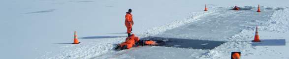 Three firefighters train in a hole in ice.