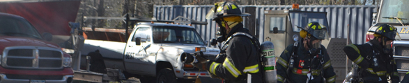 Two firefighters prepare to extingush a car